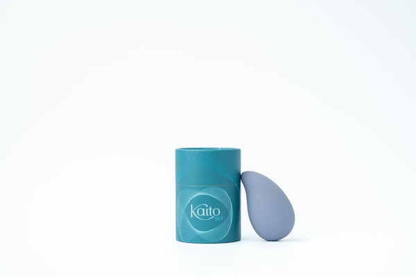 Blue Kaito Sky external vibrator beside its teal packaging