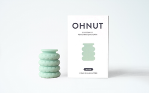 Mint green Ohnut Buffer Ring with four stackable rings beside its packaging